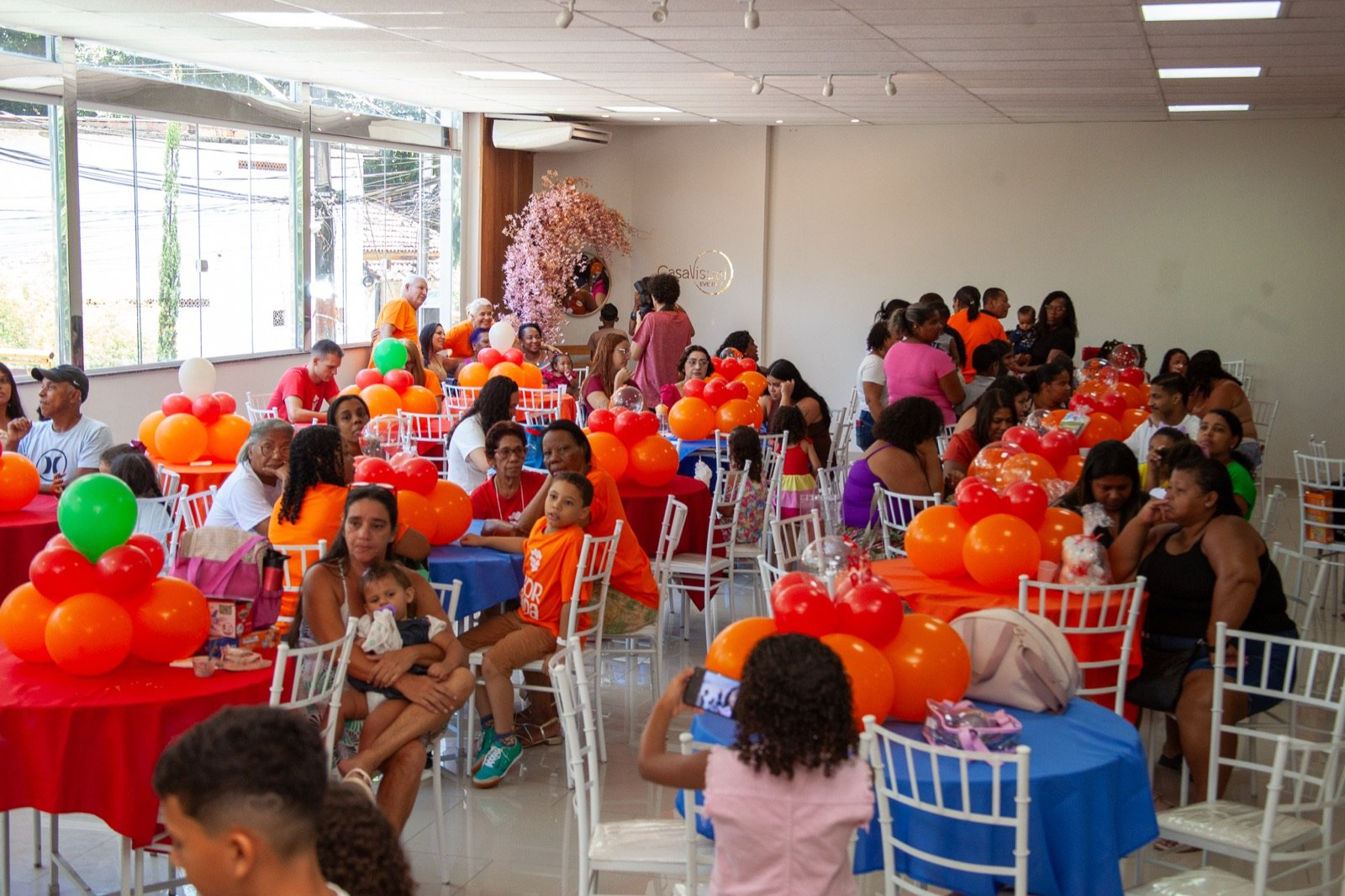 Salão preparado com mesas e balões para a festa