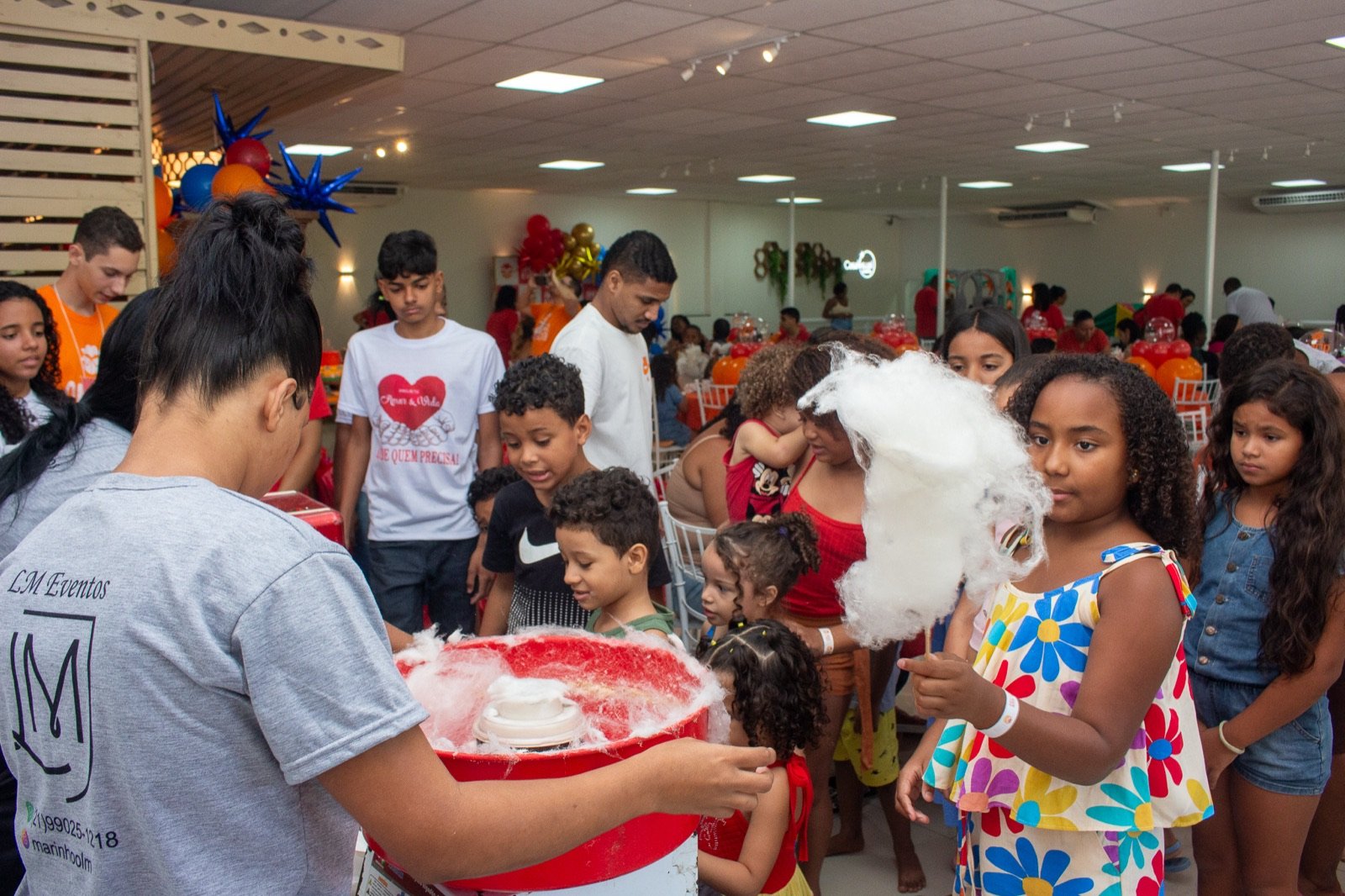 Criança recebendo algodão-doce na festa
