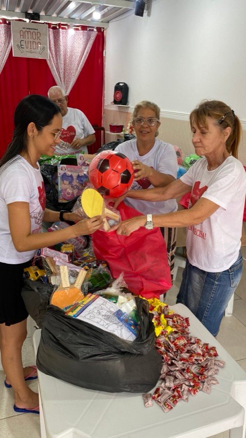 Voluntários montando as sacolas de presente do Amor e Vida