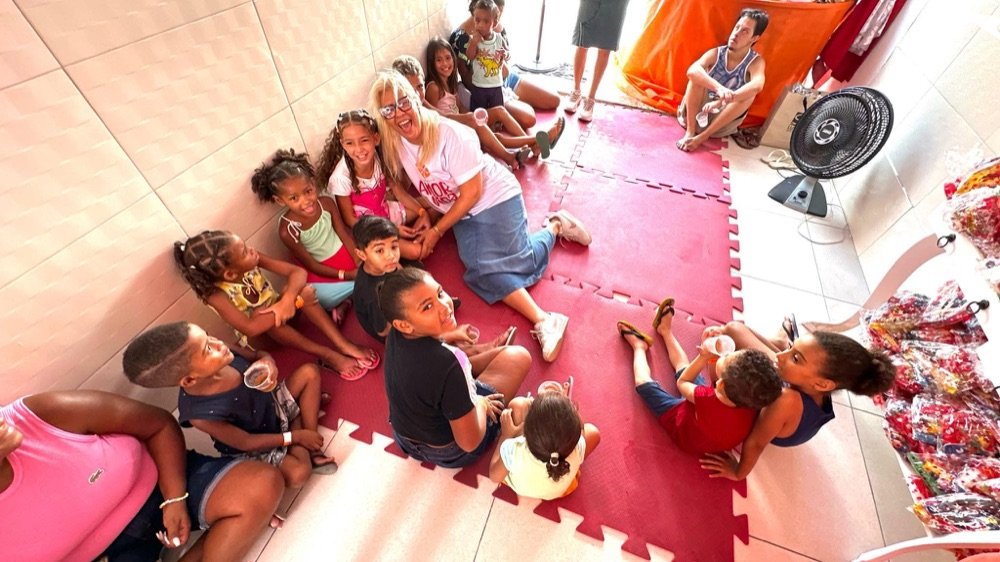 Pastora Claudia Maria sentada em roda com as crianças do Amor e Vida